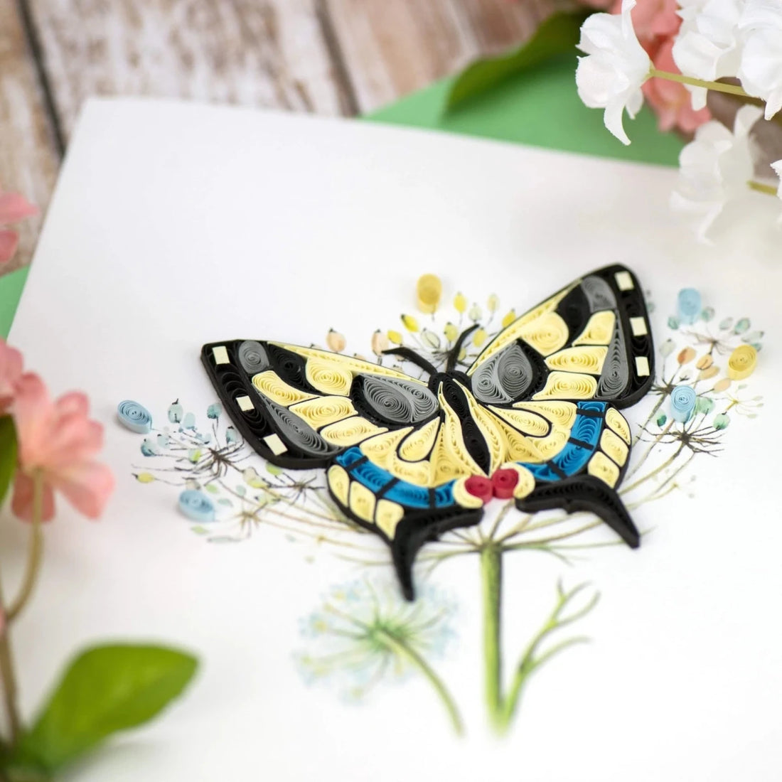 Decorative butterfly design on a white surface with flowers in the background - okotoks hc pharmacy