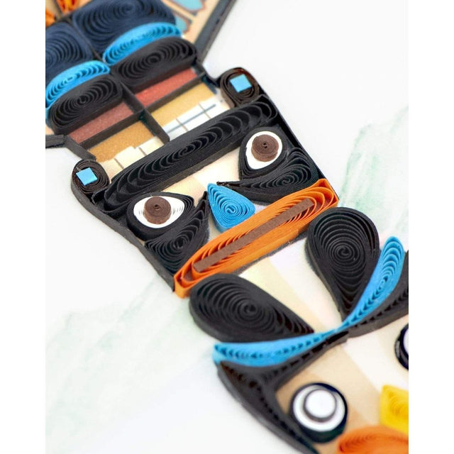 Quilled paper owl with black, blue, and orange feathers on a white background - okotoks hc pharmacy