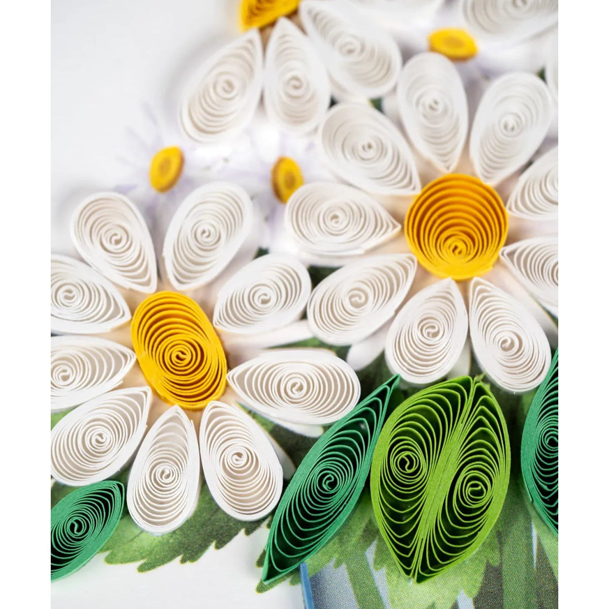 Close-up of a paper flower with white petals and yellow centers on a white background - okotoks hc pharmacy