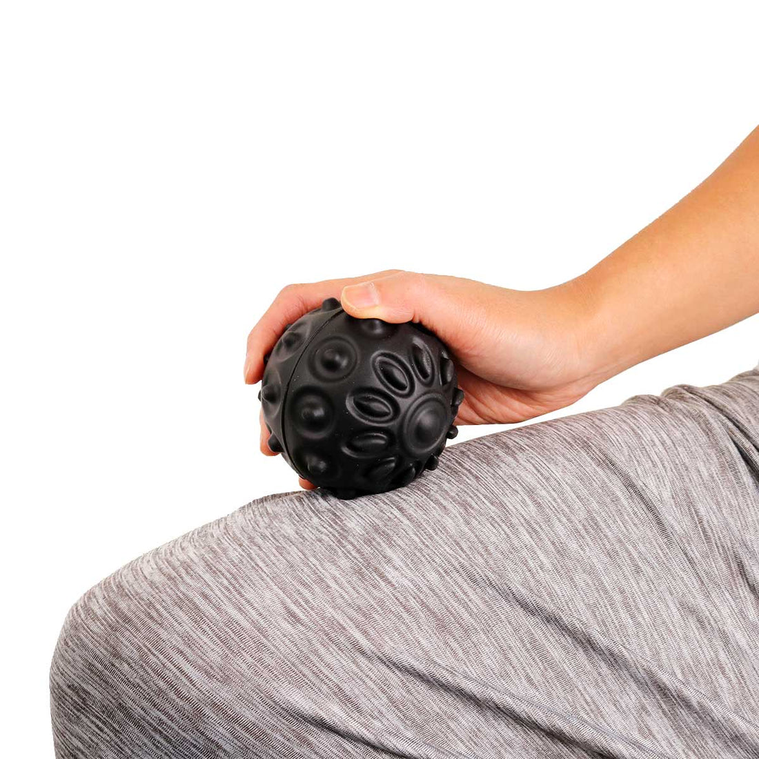 Hand holding a black textured ball against a white background - okotoks hc pharmacy