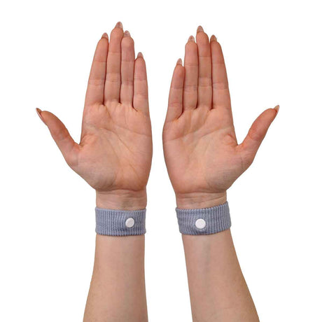 Pair of hands wearing blue wristbands with white buttons on a white background - okotoks hc pharmacy