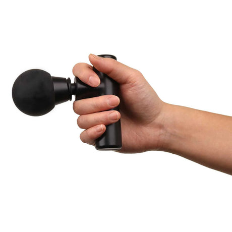 Hand holding a black massage gun against a white background - okotoks hc pharmacy