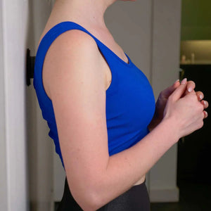 Person wearing a blue tank top in an indoor setting - okotoks hc pharmacy