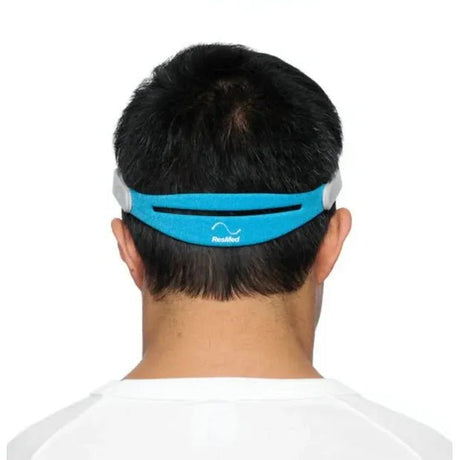 Person wearing a blue and gray headband with a visible brand logo on a white background - okotoks hc pharmacy