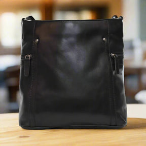 Black leather handbag on a wooden surface with a blurred background - okotoks hc pharmacy