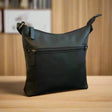 Black leather handbag on a wooden surface with a blurred background - okotoks hc pharmacy