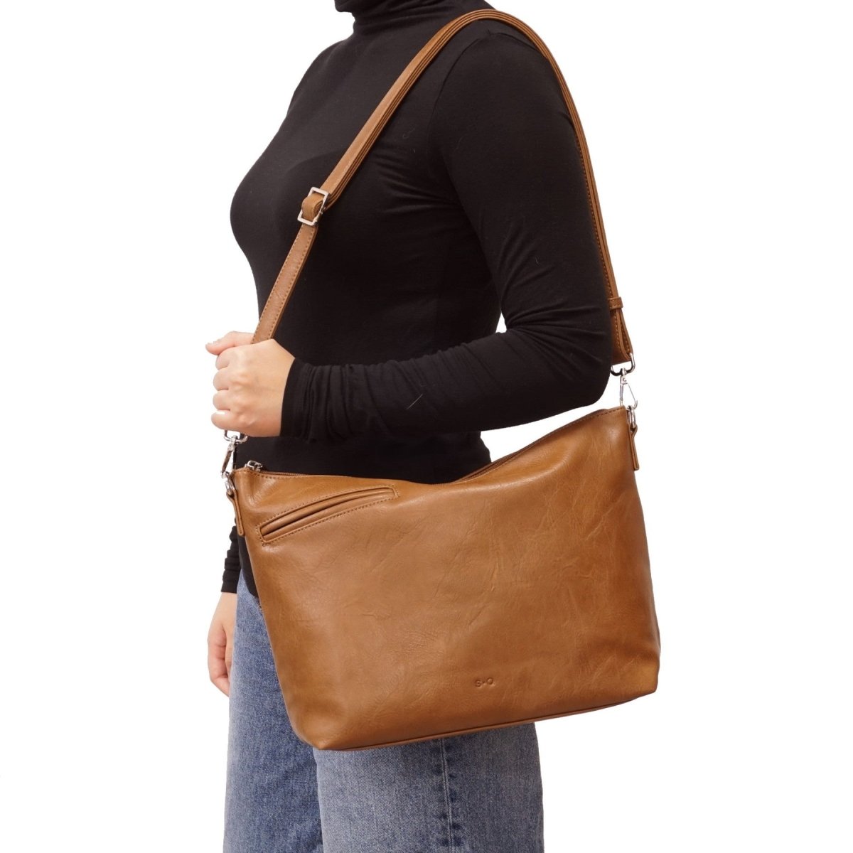 Person wearing a brown leather shoulder bag on a white background - okotoks hc pharmacy