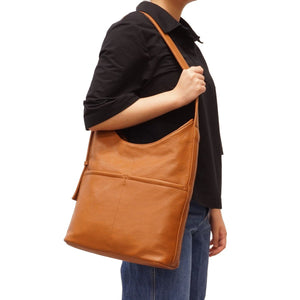 Person holding a brown leather bag on a white background - okotoks hc pharmacy