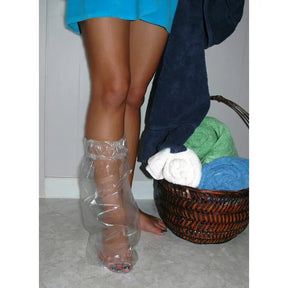 Person wearing clear plastic boot covers standing next to a laundry basket with clothes. - okotoks hc pharmacy
