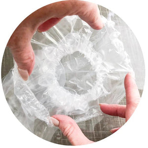 Person holding a roll of clear plastic wrap - okotoks hc pharmacy