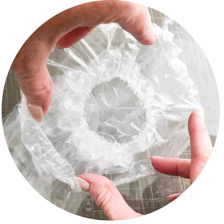 Person holding a roll of clear plastic wrap - okotoks hc pharmacy