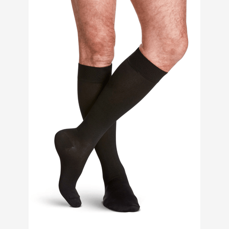 Black knee-high socks worn by a person on a white background - okotoks hc pharmacy