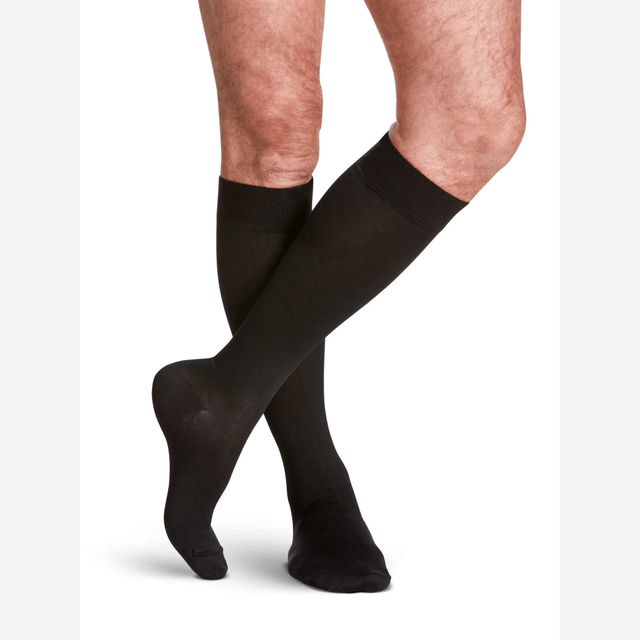 Black knee-high socks worn by a person on a white background - okotoks hc pharmacy