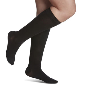Black knee-high socks worn by a person on a white background - okotoks hc pharmacy
