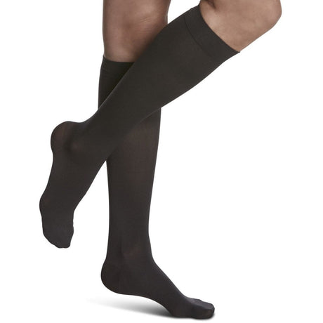 Black knee-high socks worn by a person on a white background - okotoks hc pharmacy