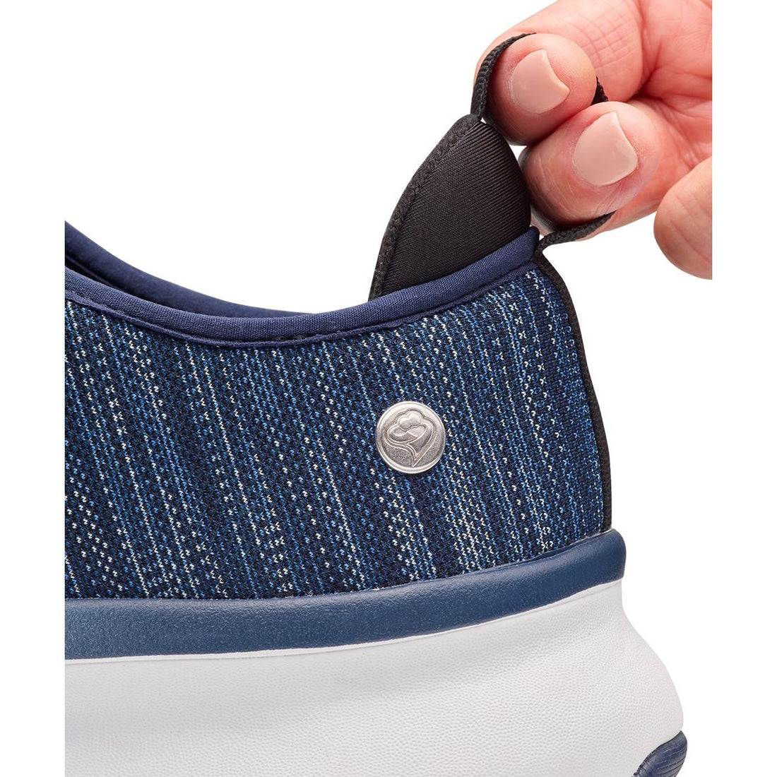 Close-up of a blue sneaker with a button being adjusted by a hand on a white background - okotoks hc pharmacy