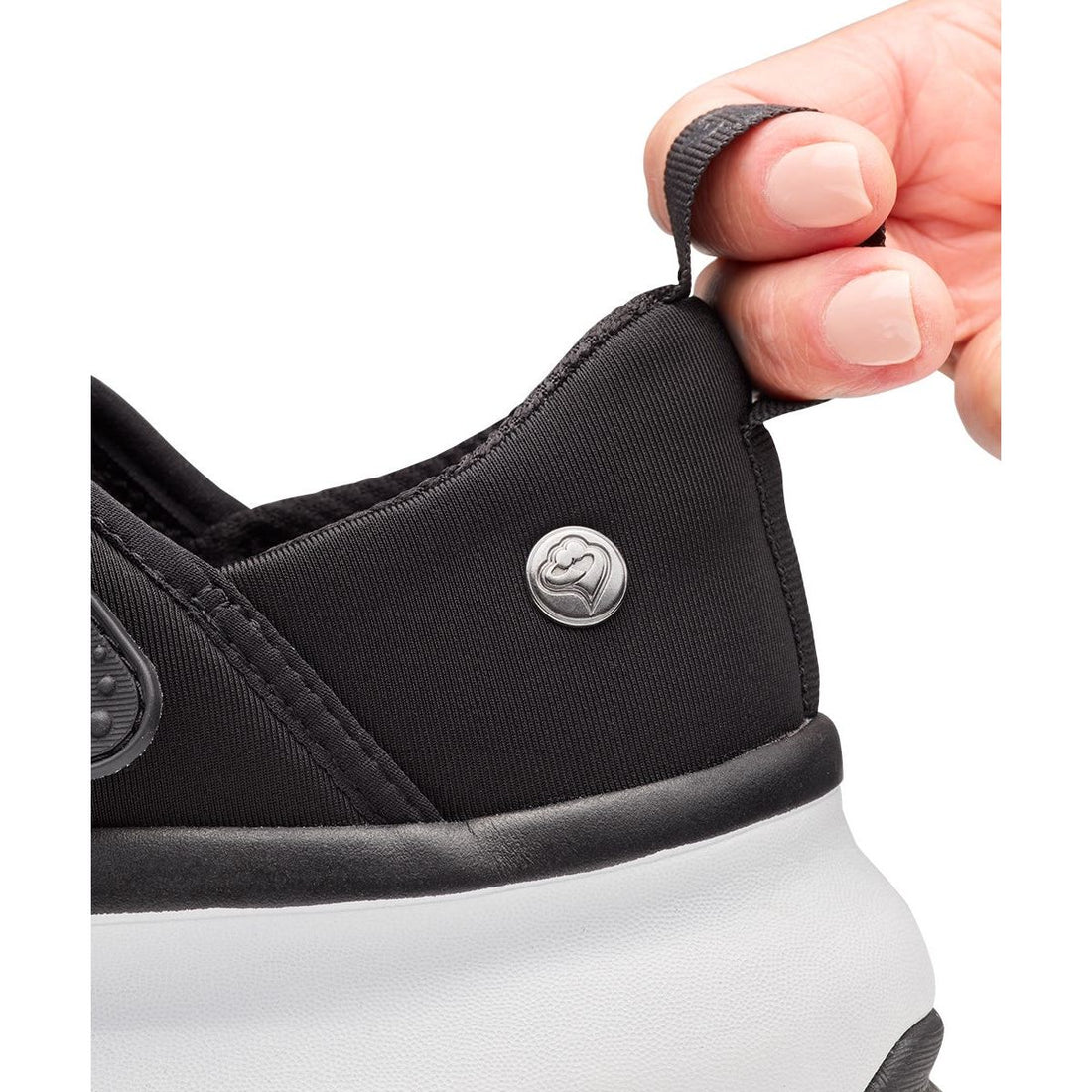 Close-up of a black sneaker with a white sole, featuring a brand logo on the side. - okotoks hc pharmacy
