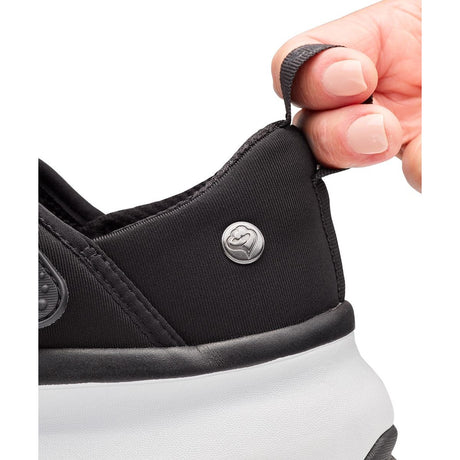 Close-up of a black sneaker with a white sole, featuring a brand logo on the side. - okotoks hc pharmacy