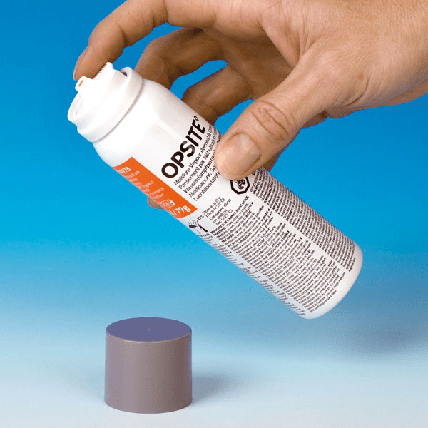 Hand holding an Opsite medical dressing against a blue background - okotoks hc pharmacy