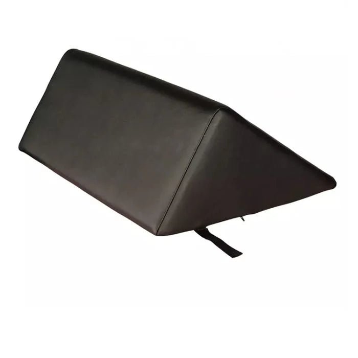 A black wedge-shaped support cushion or pillow with a small black strap hanging from the bottom corner, shown on a plain white background. - okotoks hc pharmacy