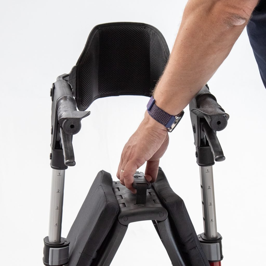 Person adjusting a black and gray walker on a white background - okotoks hc pharmacy