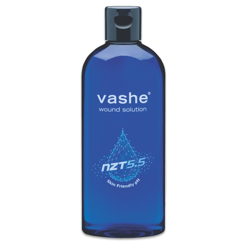A blue plastic bottle of vashe wound solution with a dark gray cap, shown against a plain white background. - okotoks hc pharmacy
